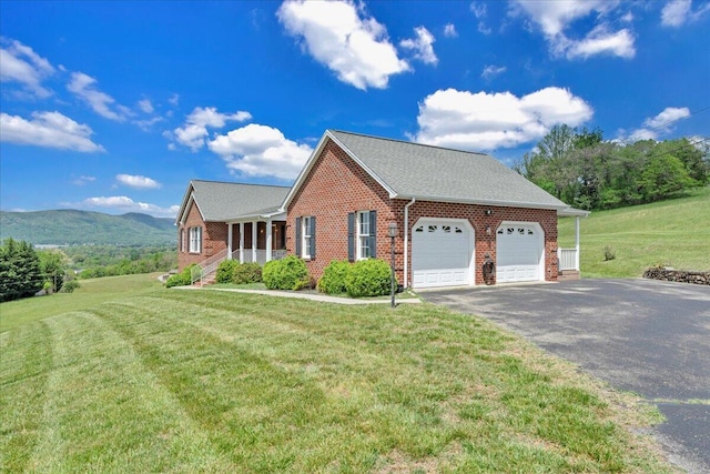 view of side of home featuring a lawn, an attached garage, driveway, and brick siding