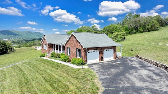 exterior space with brick siding, a garage, driveway, and a front yard