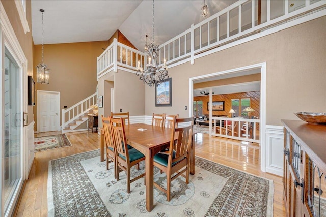5319 Mcvitty Rd, Roanoke, VA 24018 - dining area featuring a chandelier, stairway, wood finished floors, high vaulted ceiling, and wainscoting