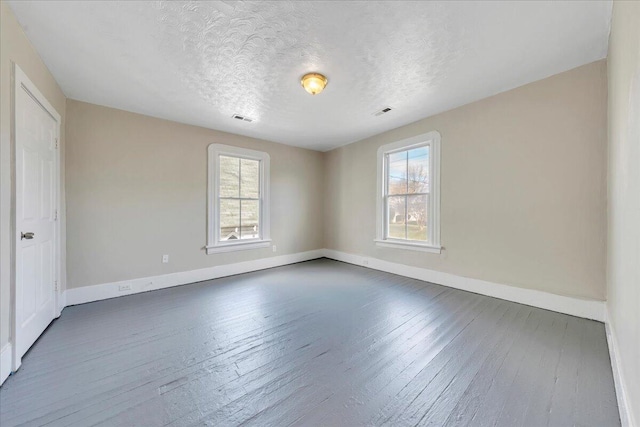1012 Loudon Ave NW, Roanoke, VA 24016 - unfurnished bedroom with baseboards, visible vents, multiple windows, and hardwood / wood-style flooring