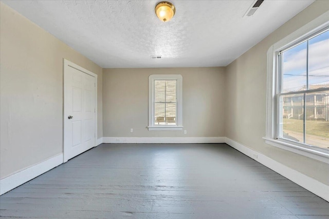 1012 Loudon Ave NW, Roanoke, VA 24016 - unfurnished room with a textured ceiling, plenty of natural light, and wood finished floors