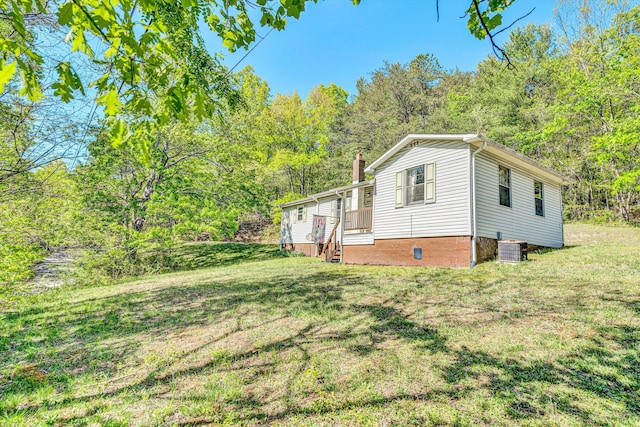 view of property exterior with a yard, cooling unit, and a chimney