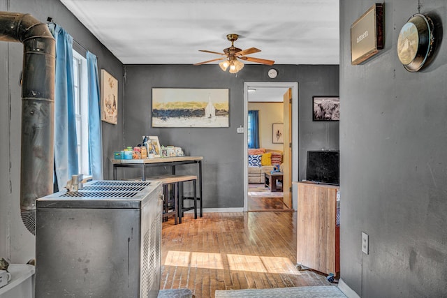 corridor featuring wood-type flooring and baseboards