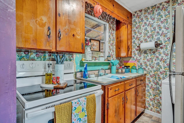 kitchen featuring a sink, brown cabinets, white electric range, and wallpapered walls
