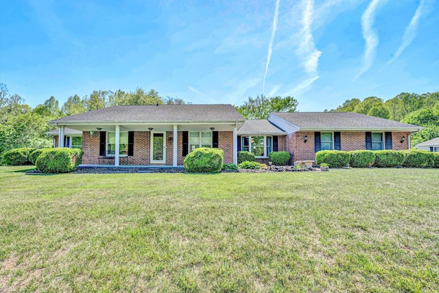 ranch-style home featuring brick siding, a front lawn, and a porch
