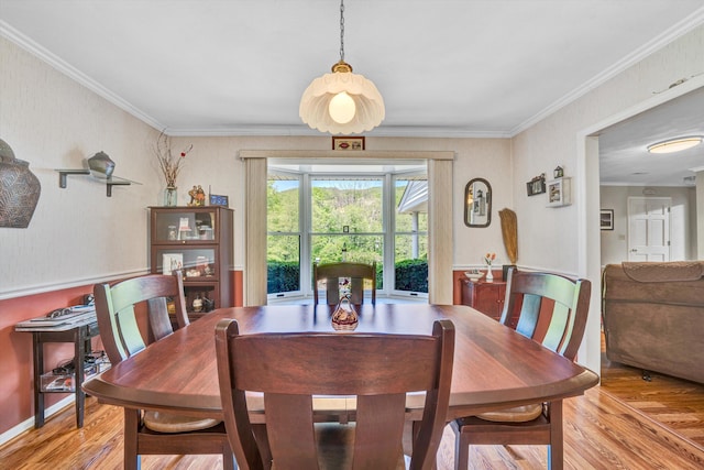 dining area with ornamental molding and wood finished floors
