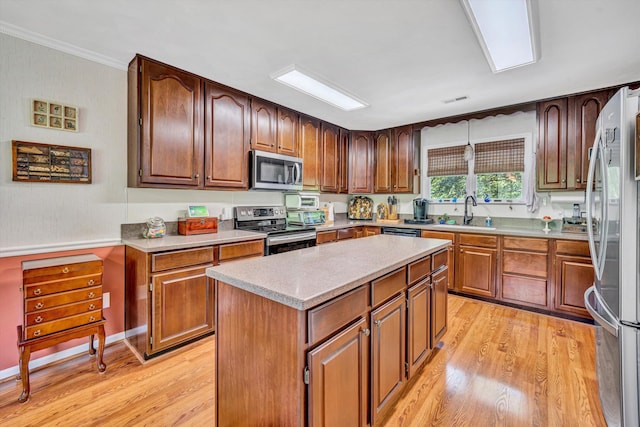 kitchen with a sink, light countertops, stainless steel appliances, and light wood-style flooring