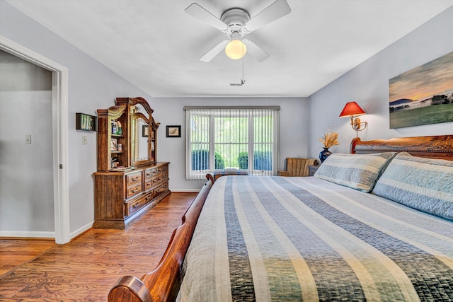 bedroom with a ceiling fan, baseboards, and wood finished floors