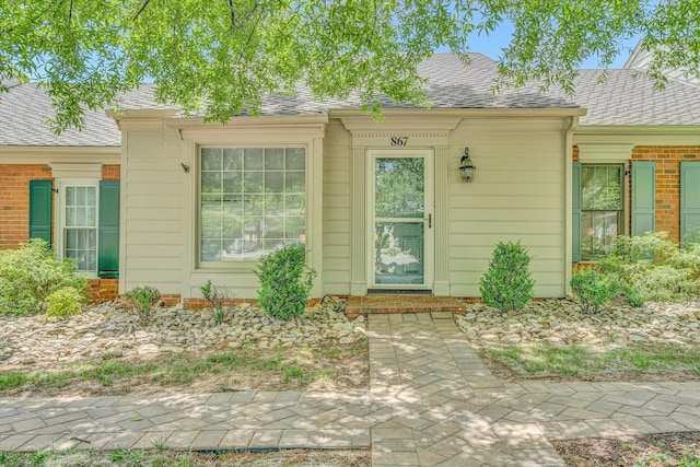 property entrance with a shingled roof
