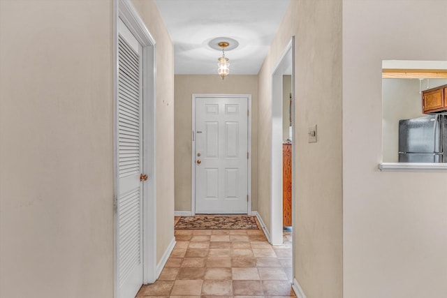 hall featuring baseboards and stone finish flooring