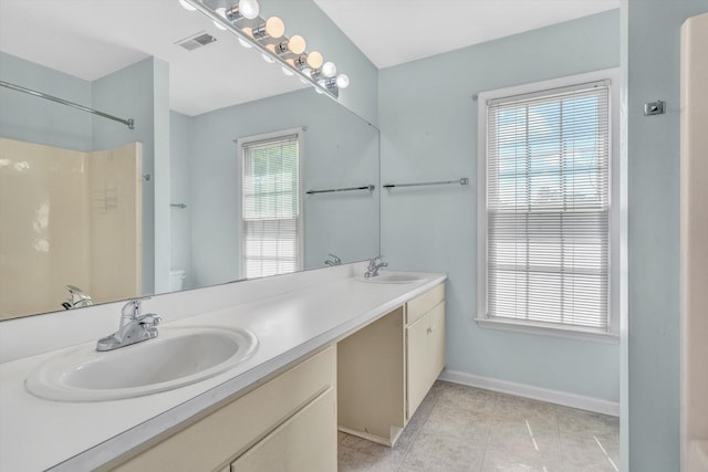 bathroom with double vanity, visible vents, a sink, tile patterned floors, and toilet