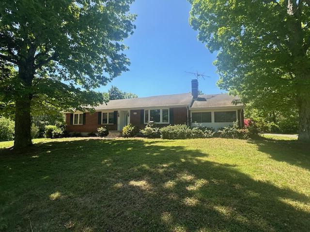 view of front of house with a chimney and a front lawn