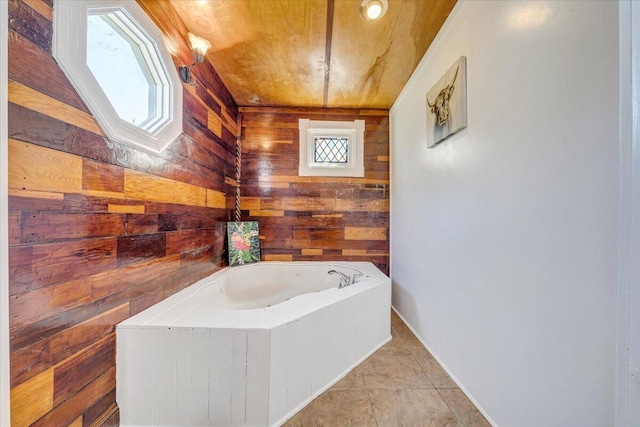 full bath with wooden walls, baseboards, tile patterned flooring, and a bath