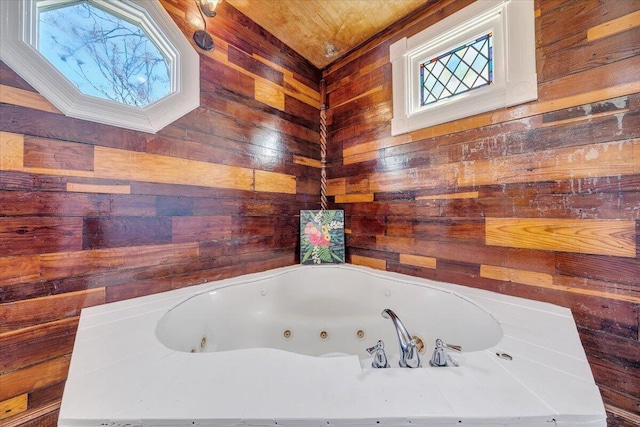 full bathroom featuring wooden walls and a whirlpool tub