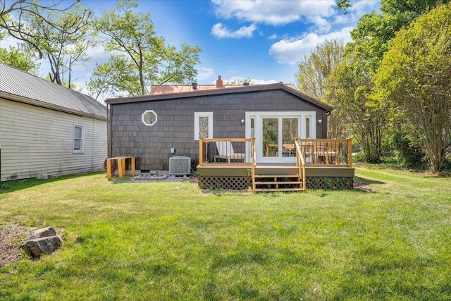 rear view of house with a lawn, a chimney, central air condition unit, and a deck