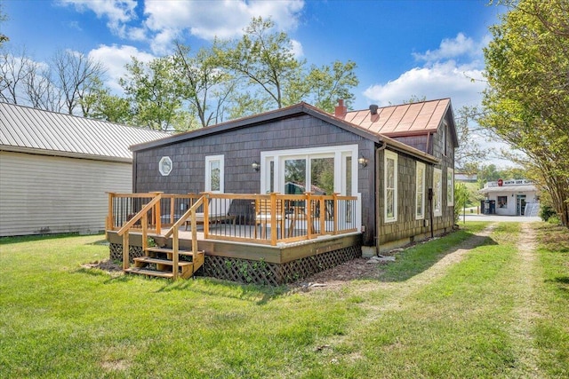 rear view of property featuring a yard and a deck