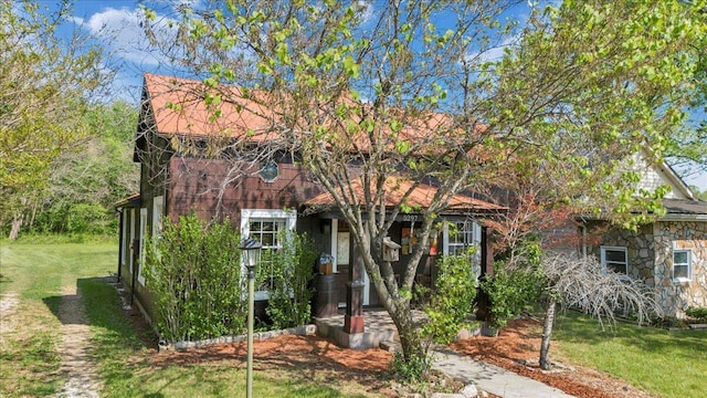 view of front facade featuring a front lawn and stone siding