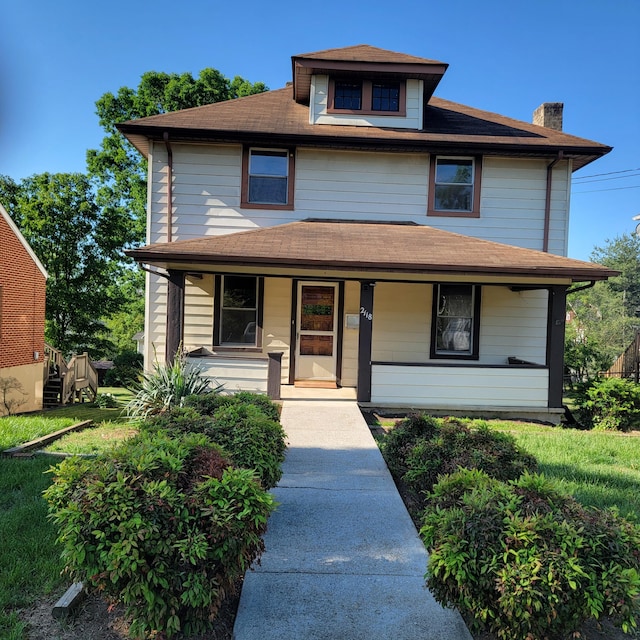 traditional style home featuring a shingled roof, covered porch, and a chimney