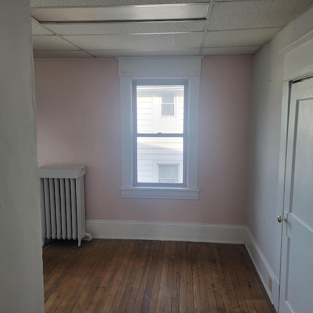 2118 Berkley Ave SW, Roanoke, VA 24015 - spare room with a drop ceiling, radiator heating unit, dark wood-style floors, and baseboards