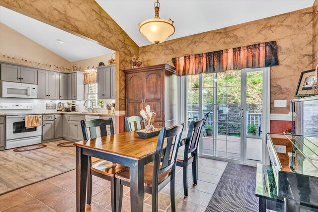 dining space featuring light tile patterned floors and lofted ceiling