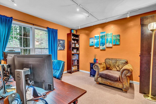 carpeted office featuring rail lighting and baseboards