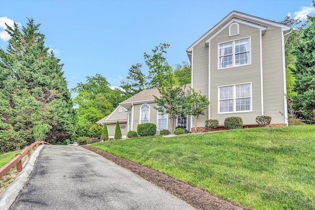view of front of property with driveway and a front lawn