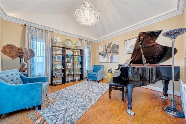 sitting room with a chandelier, wood finished floors, vaulted ceiling, crown molding, and baseboards