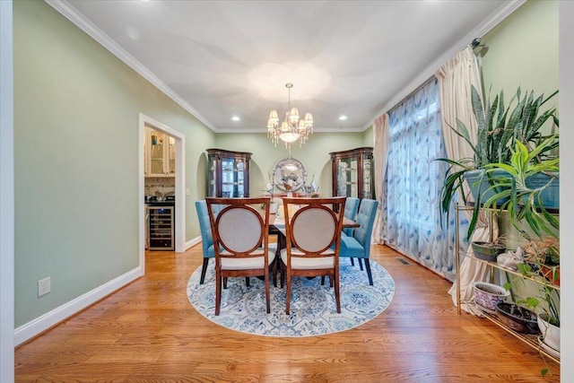 dining space featuring beverage cooler, a chandelier, plenty of natural light, baseboards, and recessed lighting