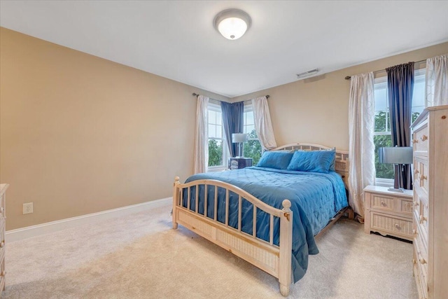 bedroom with light colored carpet and baseboards
