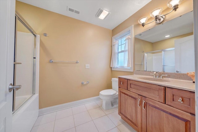 bathroom with baseboards, tile patterned floors, toilet, vanity, and shower / bath combination with glass door