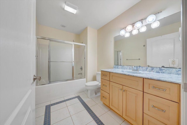 bathroom with tile patterned floors, toilet, enclosed tub / shower combo, and vanity