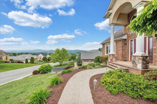 view of grassy yard featuring a mountain view and a residential view