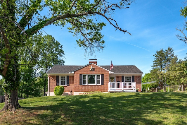 view of front of property with fence, a chimney, a front lawn, and brick siding