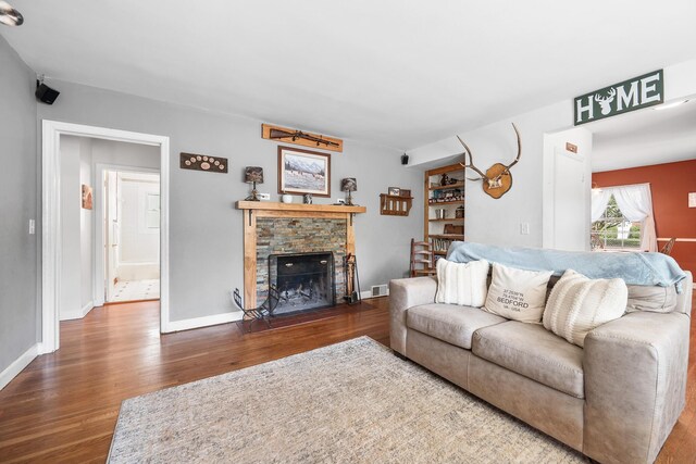 living room with visible vents, wood finished floors, and a fireplace