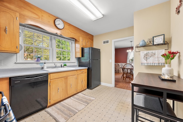 kitchen featuring visible vents, decorative backsplash, light countertops, a sink, and black appliances