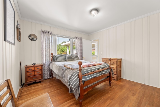 bedroom with crown molding and light wood finished floors