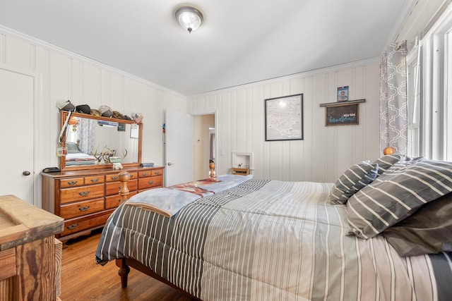 bedroom with lofted ceiling and wood finished floors