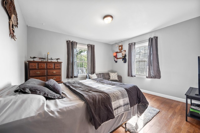 bedroom with baseboards and wood finished floors