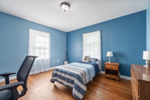 bedroom with baseboards and wood finished floors