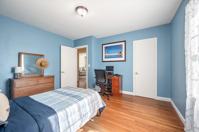 bedroom featuring baseboards and light wood finished floors