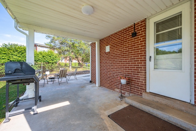 view of patio with fence, entry steps, and a grill