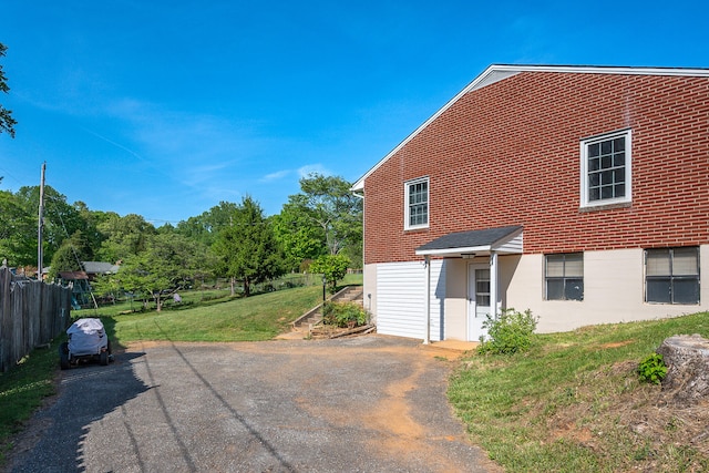 view of home's exterior featuring a yard, driveway, and fence