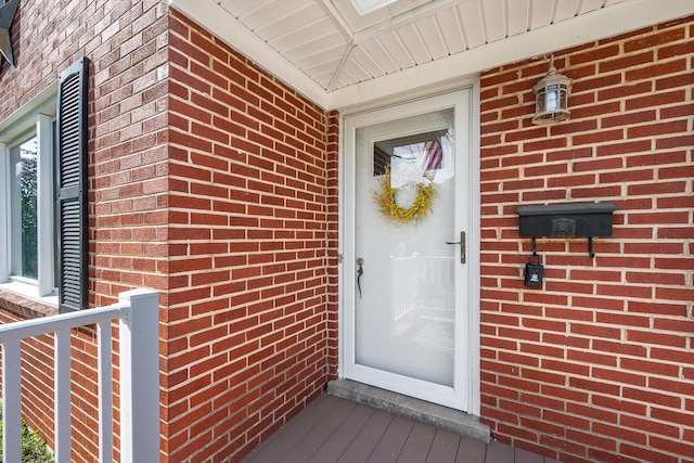 entrance to property featuring brick siding