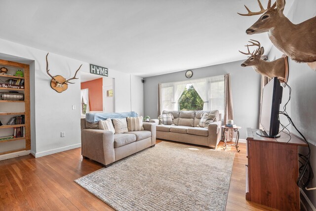 living room with baseboards and wood finished floors