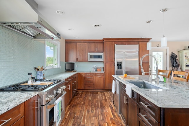 kitchen with light wood-style floors, wall chimney exhaust hood, a kitchen bar, backsplash, and stainless steel built in refrigerator
