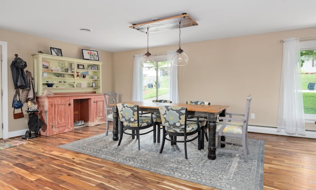 exercise room featuring baseboards, a baseboard radiator, and wood finished floors