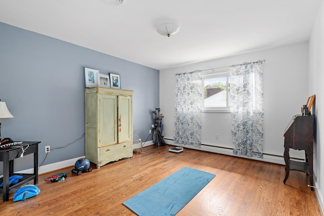 bedroom featuring a baseboard radiator, wood finished floors, and visible vents