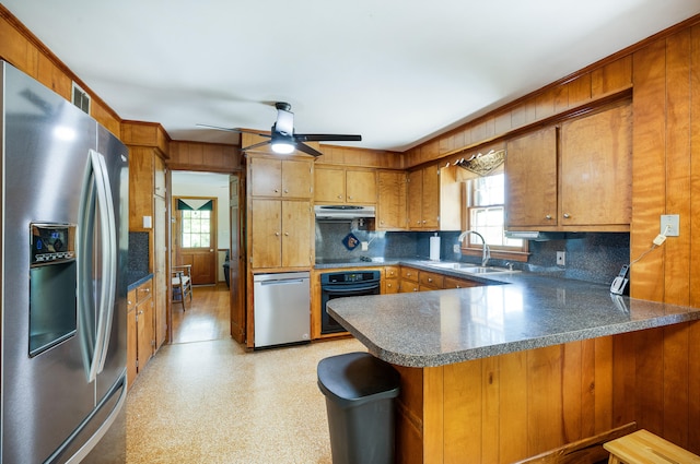 kitchen with backsplash, a sink, black appliances, a peninsula, and under cabinet range hood
