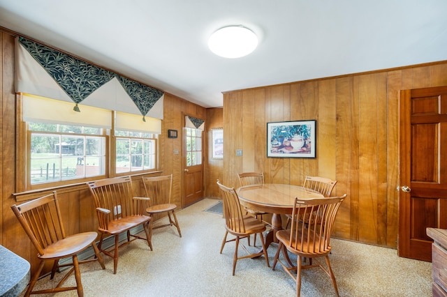dining space with wooden walls and light floors