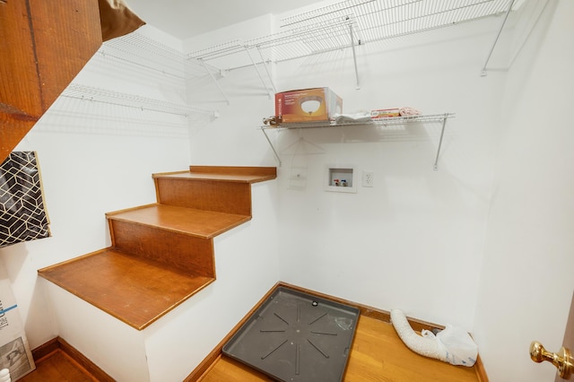 interior space with baseboards, laundry area, washer hookup, and wood finished floors